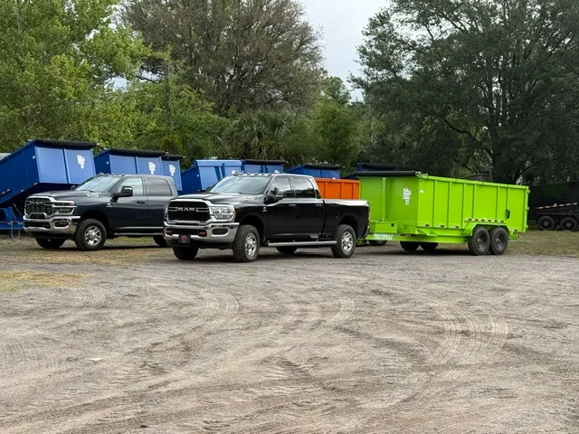 Dump trucks and trailers lined up for commercial hauling and junk removal services