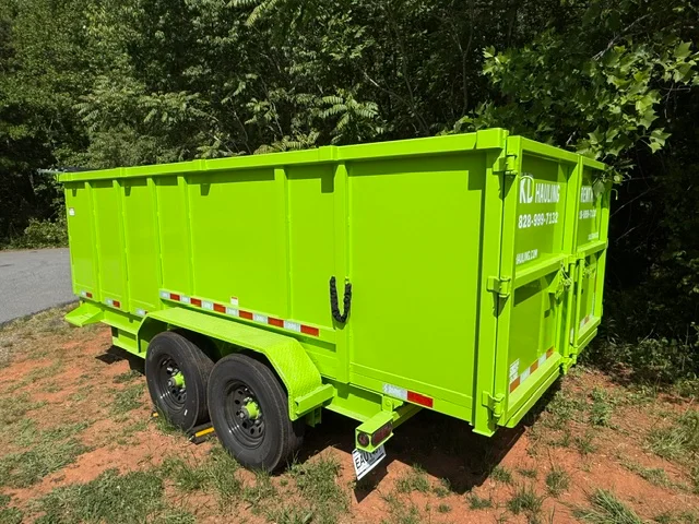 Lime-green dual-axle dump trailer with enclosed box, safety striping, and commercial hauling equipment