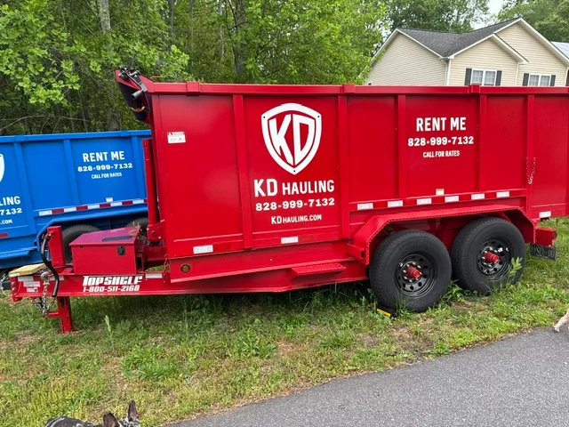 Red steel dump trailer with dual axles and hydraulic lift gate for hauling