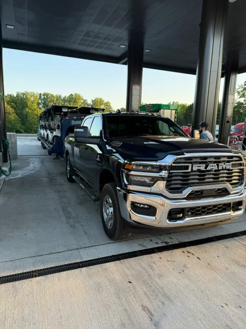 RAM pickup truck loaded on car carrier trailer under covered loading dock