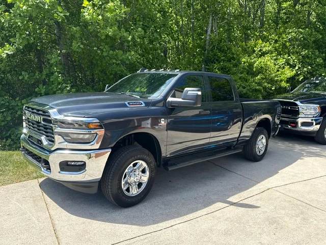 Two RAM pickup trucks parked on concrete driveway, detailed and ready for service