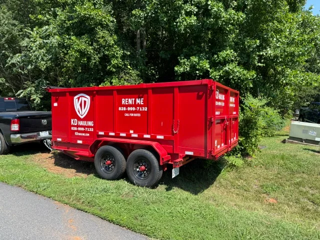 Red dual-axle enclosed hauling trailer with reflective safety striping on grass